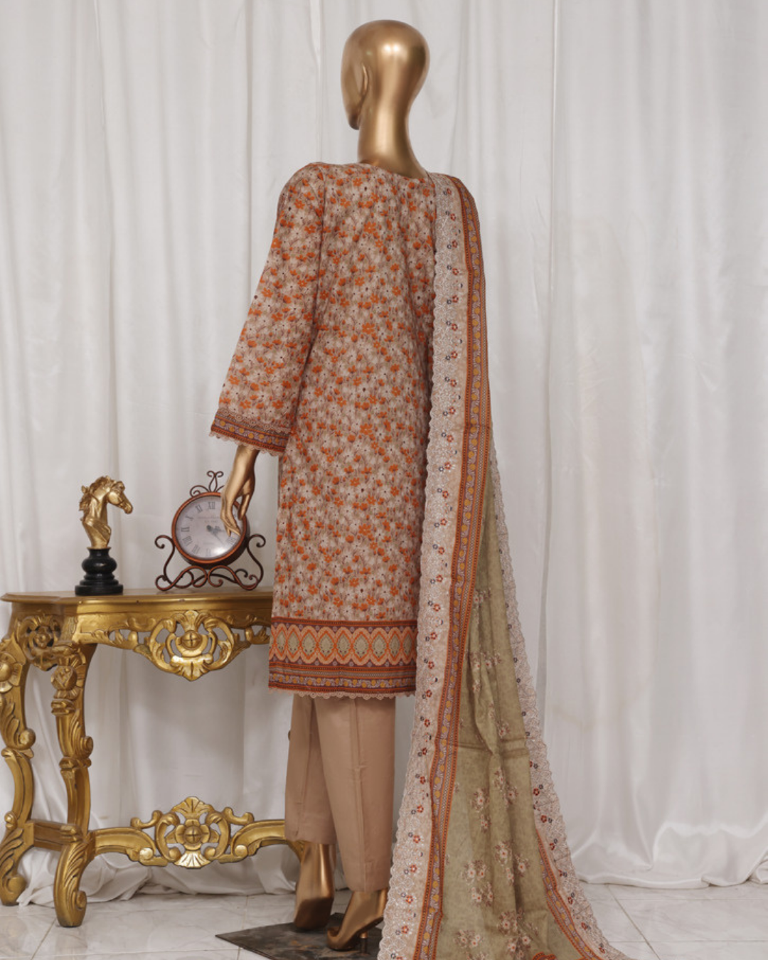 Mannequin wearing a floral dress with a dupatta in a decorative setting.