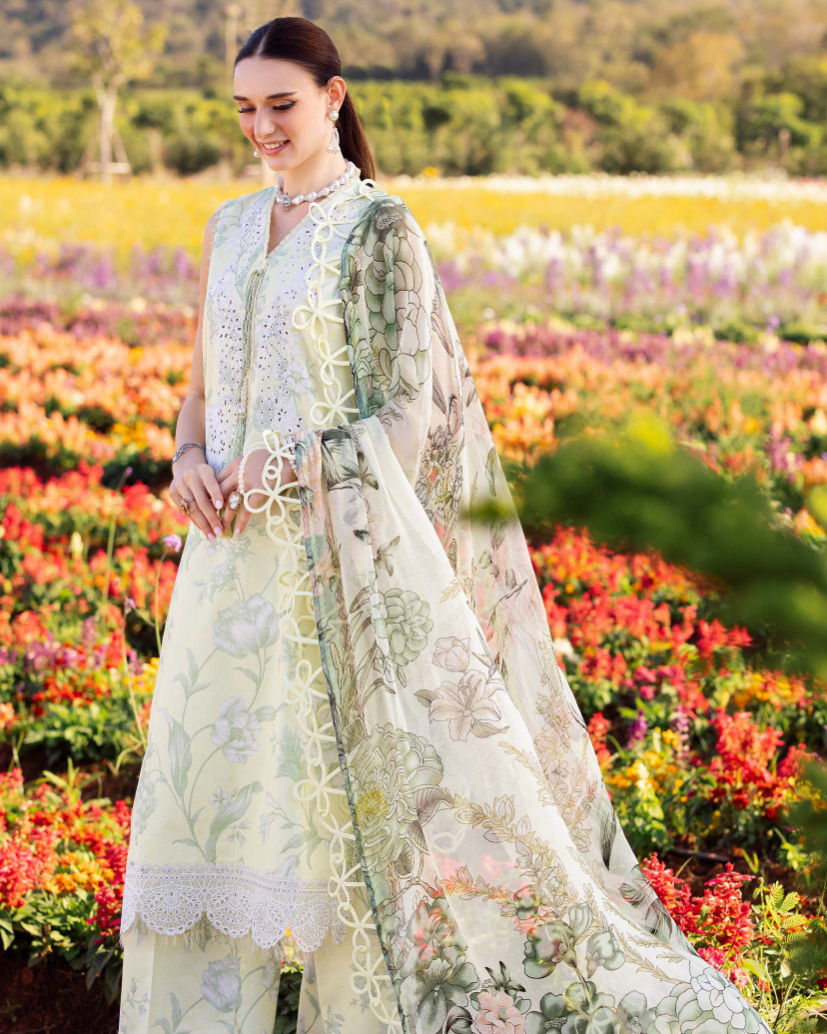 Woman in a floral dress standing in a field of colorful flowers