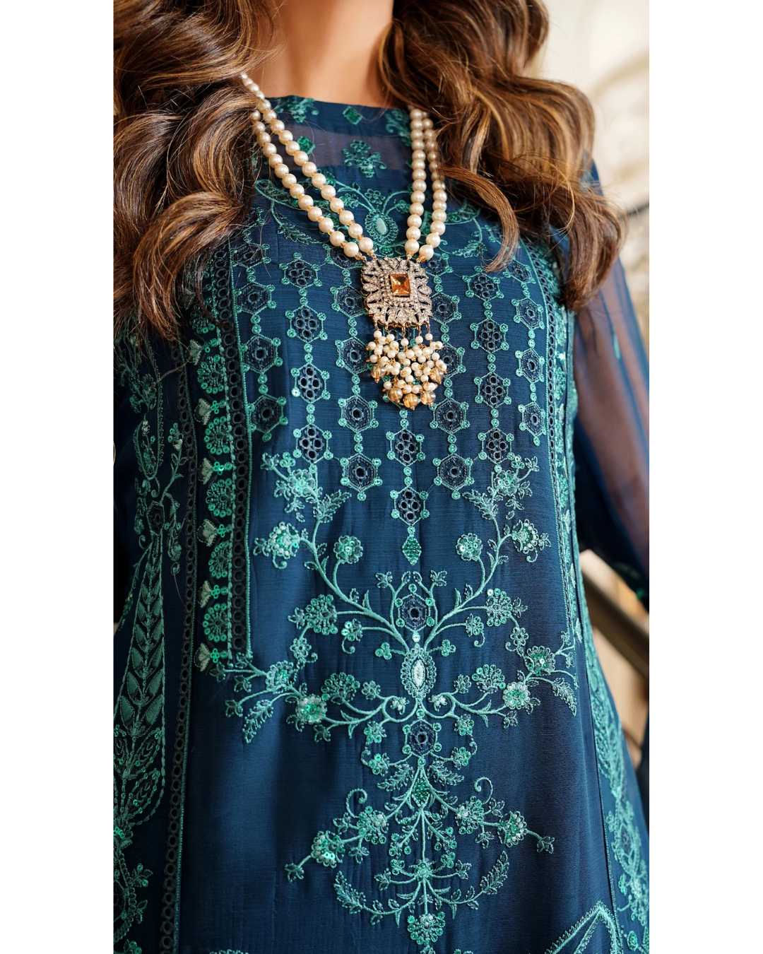 Navy blue embroidered dress with intricate patterns and a necklace.