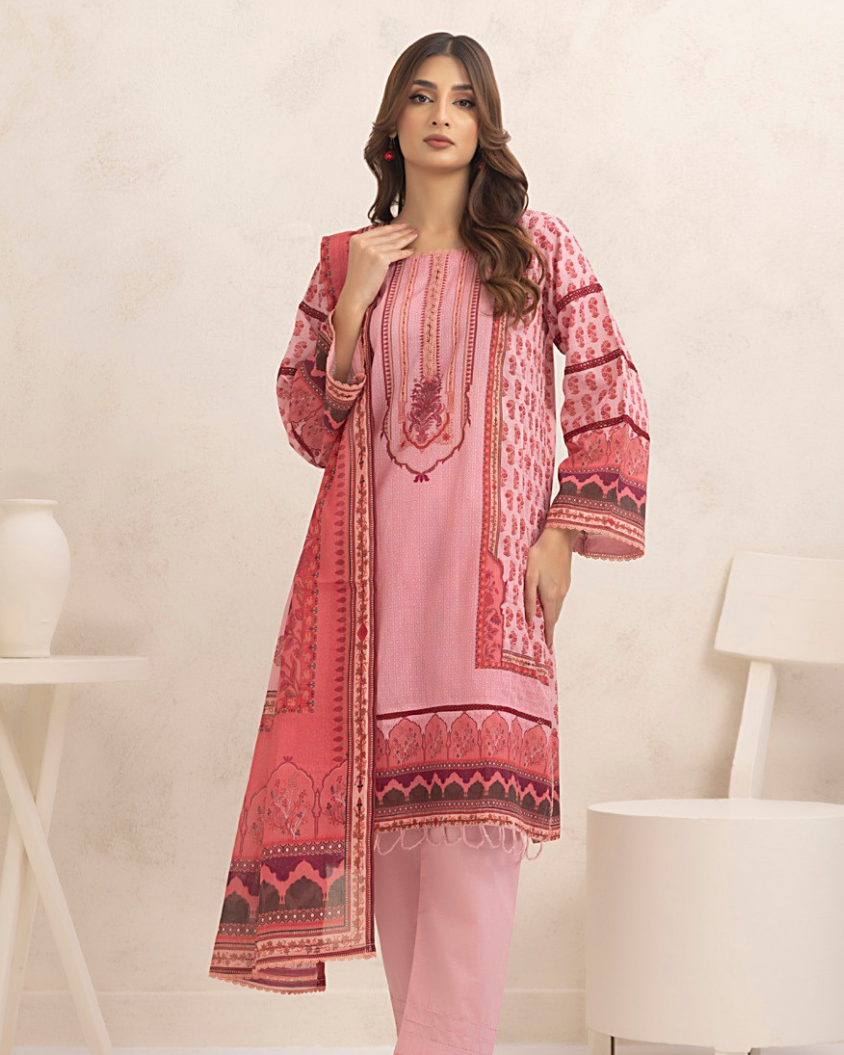 Woman wearing a pink and red patterned outfit in a minimalistic setting