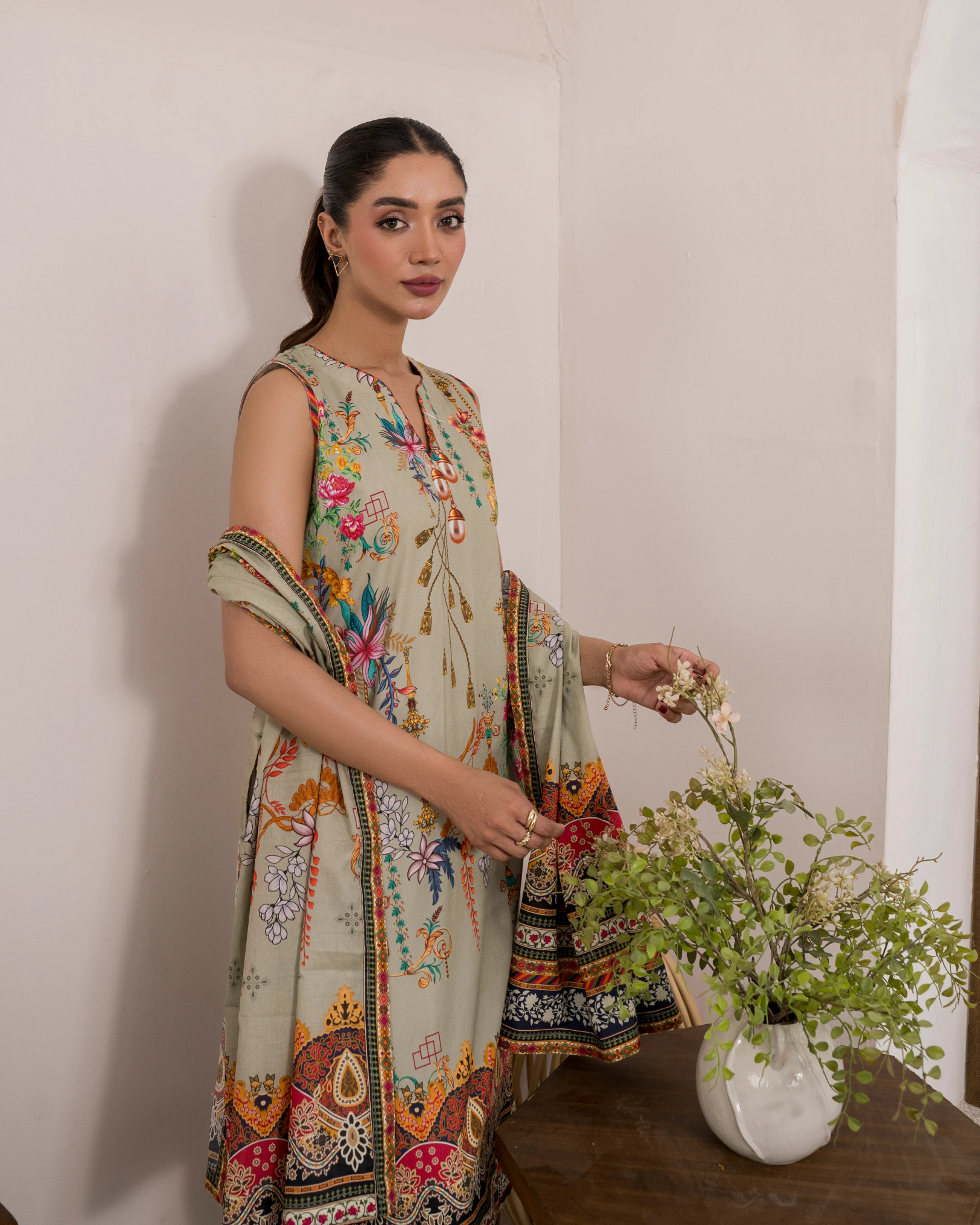 Woman in a floral dress holding flowers indoors