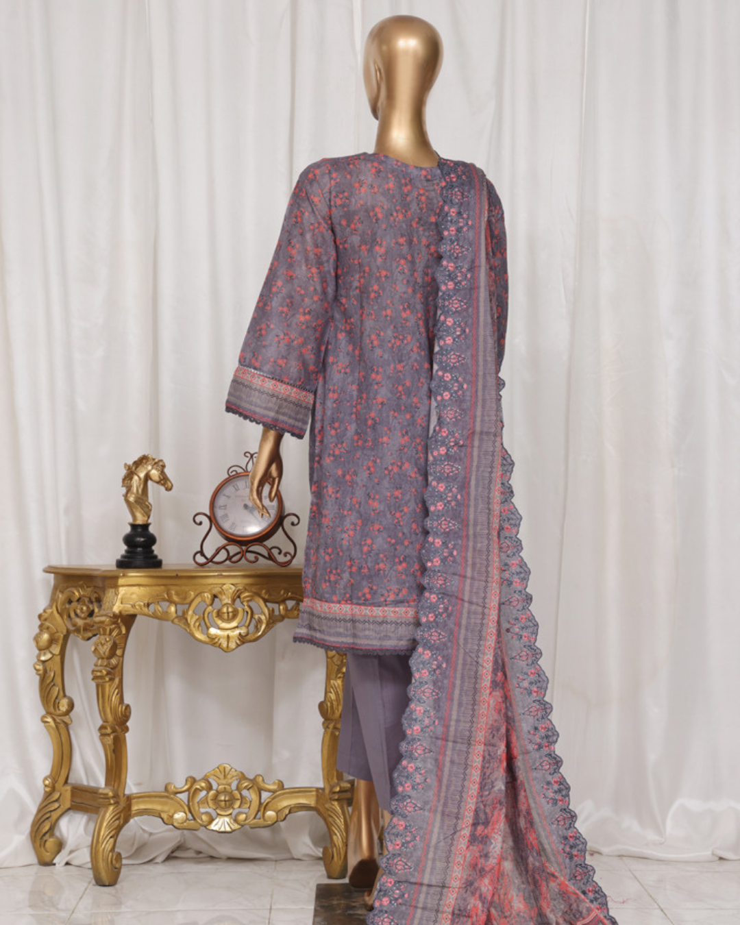 Mannequin wearing a traditional outfit with a saree draped over it, against a white curtain background.
