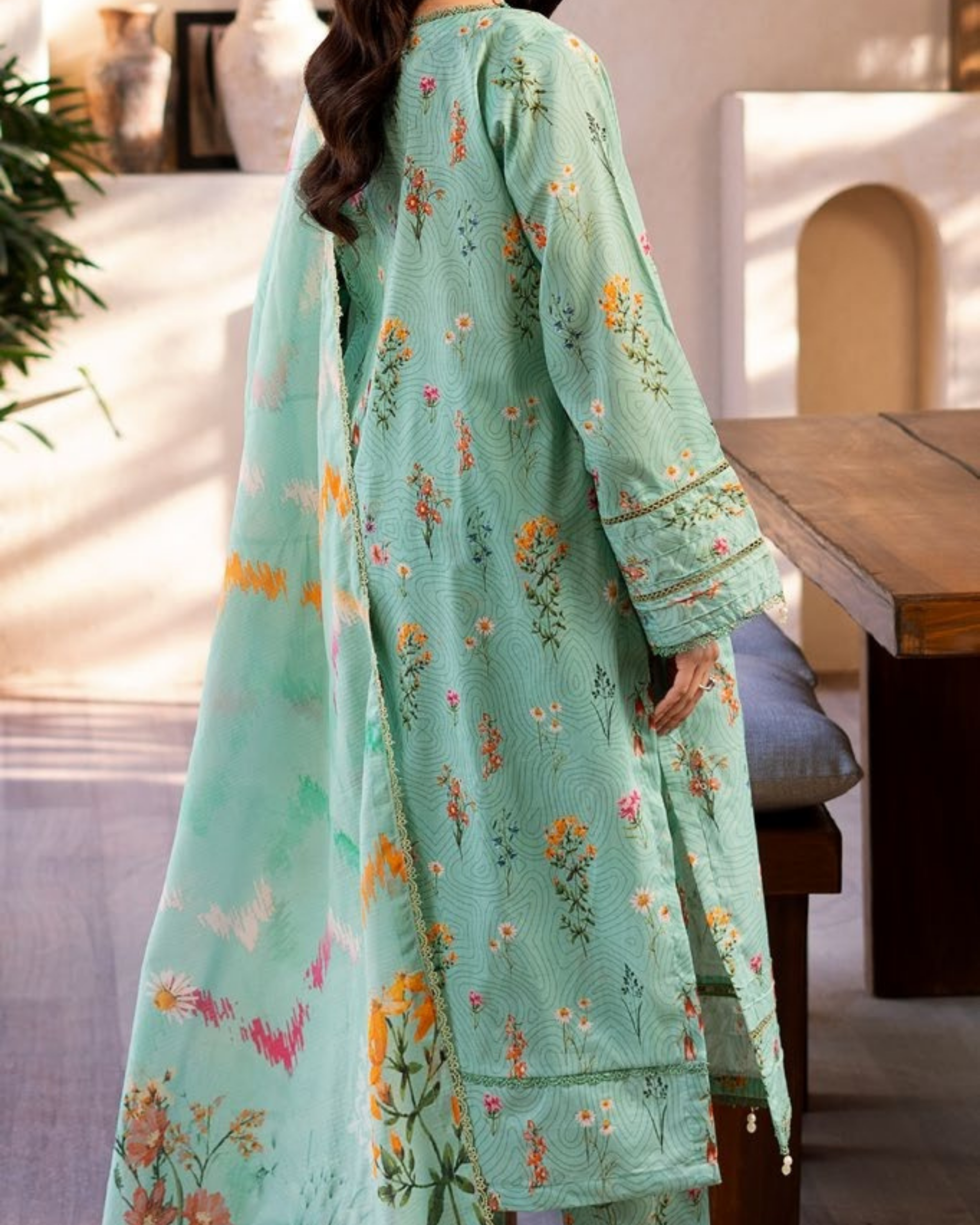Light blue embroidered traditional outfit with floral patterns in a casual setting.