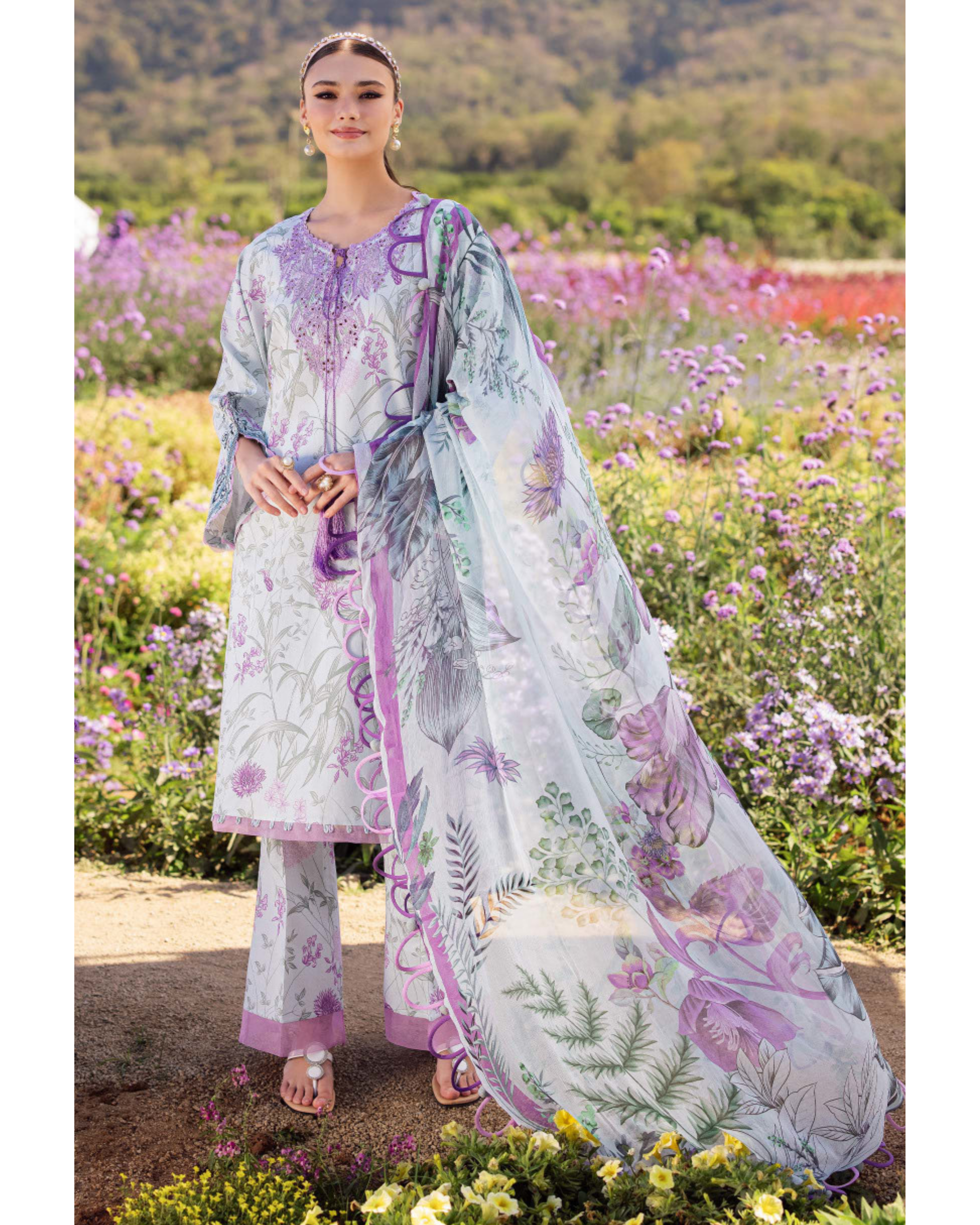 Woman in a floral outfit standing in a field of flowers