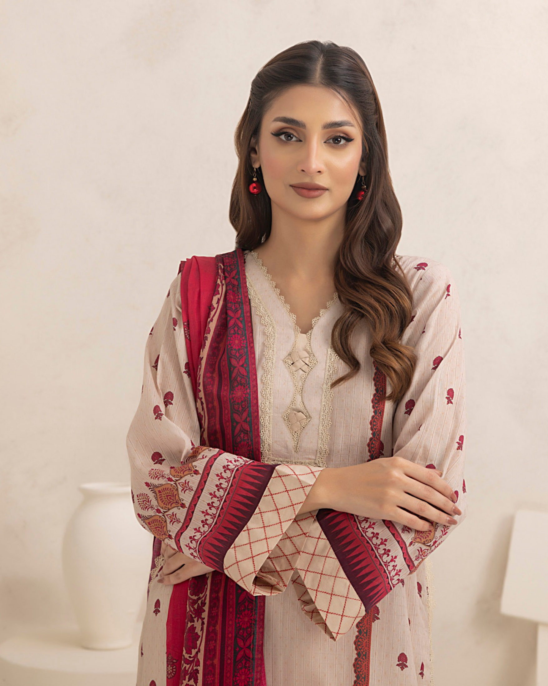 Woman wearing a traditional outfit with a red and beige patterned shawl on a white background