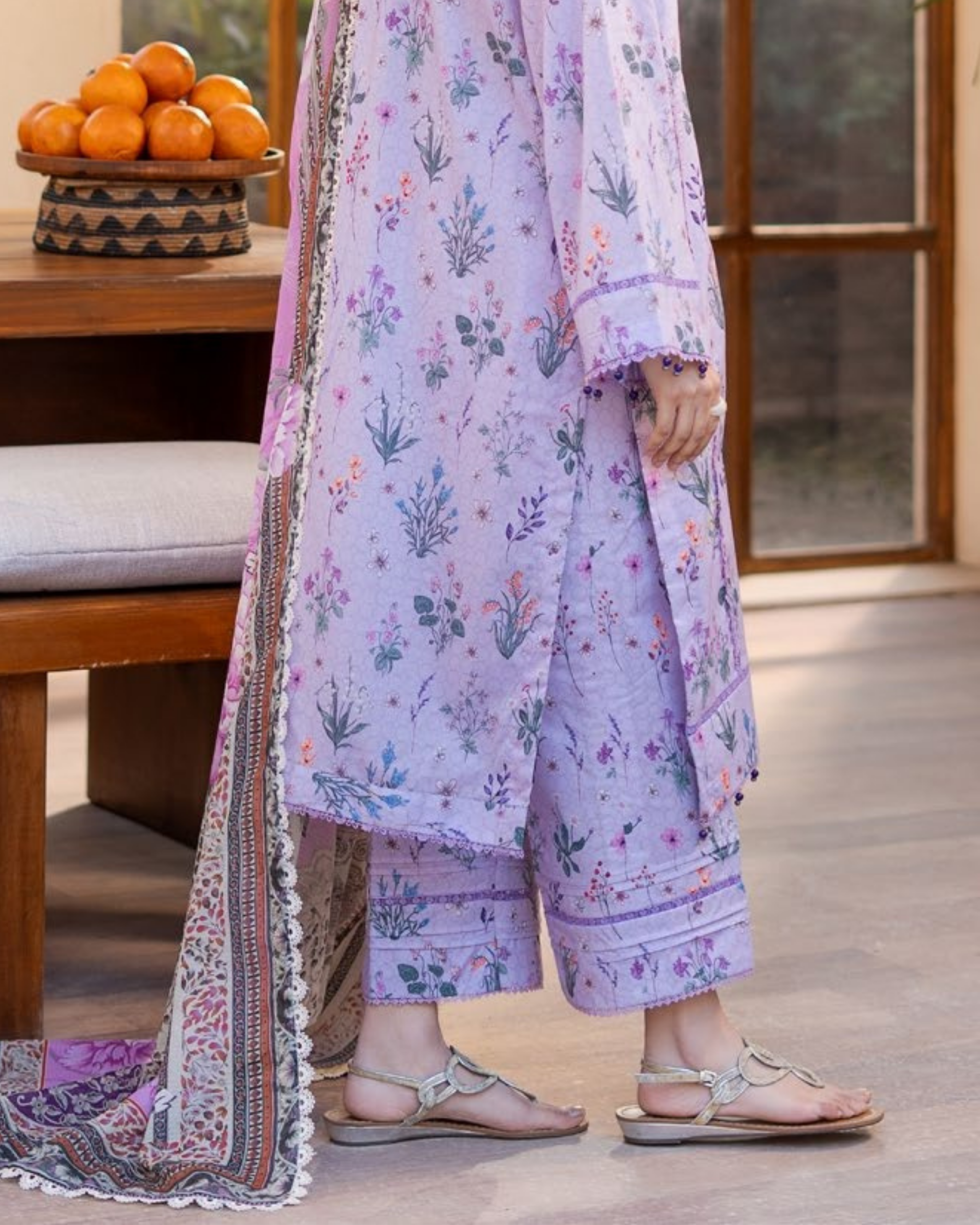 Person wearing a floral outfit with a matching shawl in a home setting.