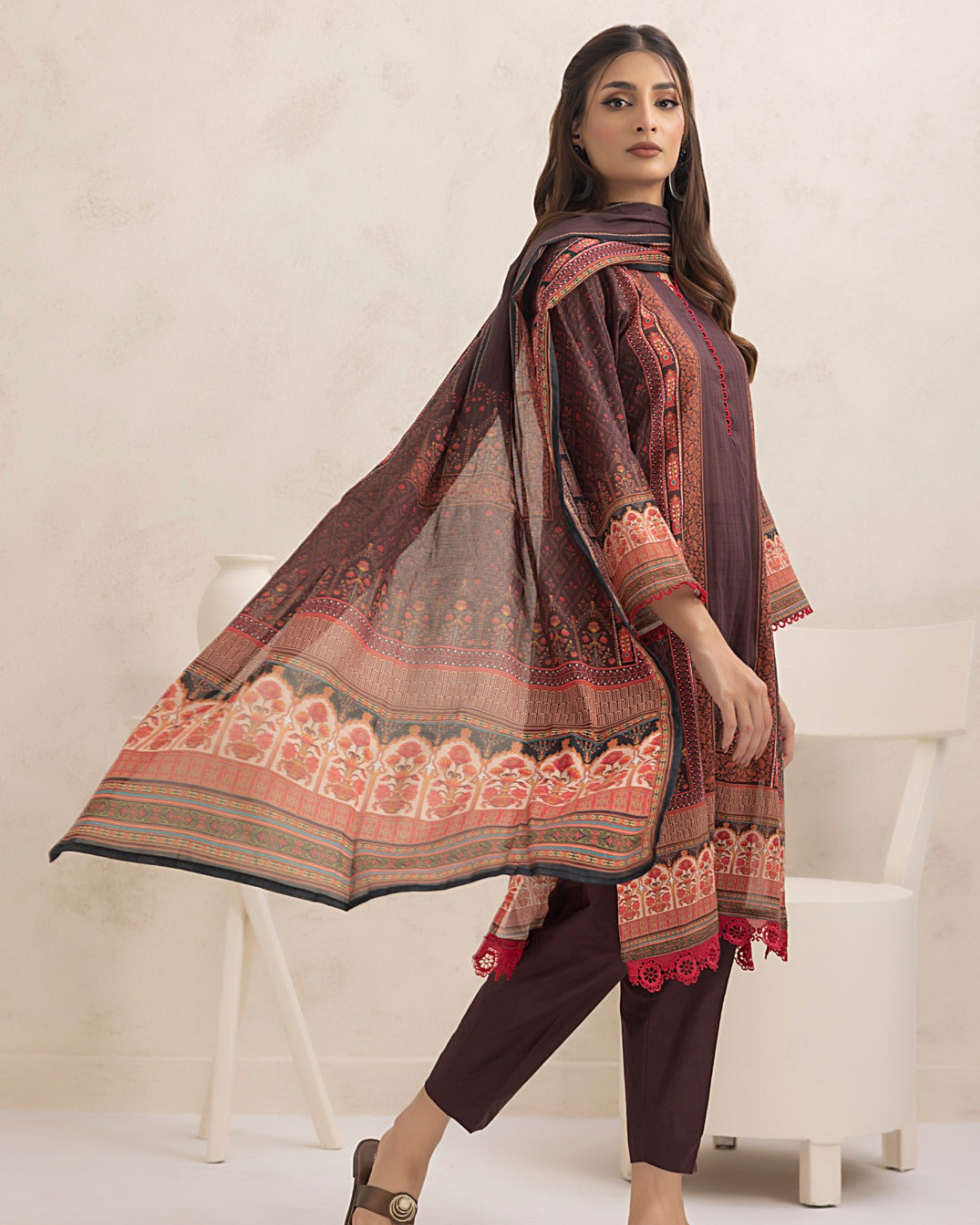 Woman wearing a traditional outfit with a patterned shawl on a white background