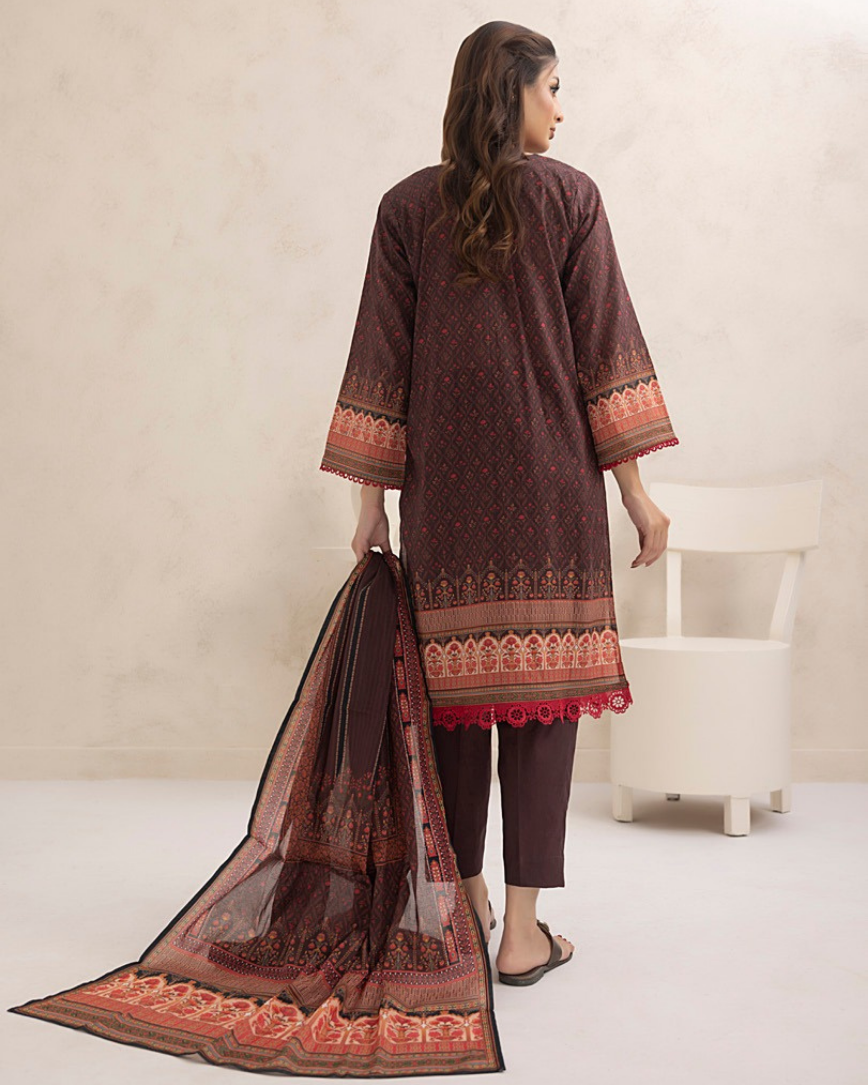 Woman wearing a brown traditional outfit with a matching dupatta on a white background