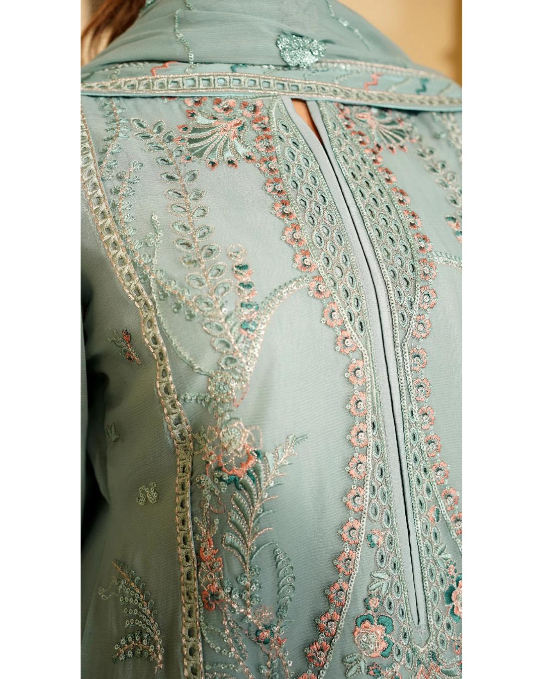 Light blue embroidered fabric with intricate patterns on a plain background
