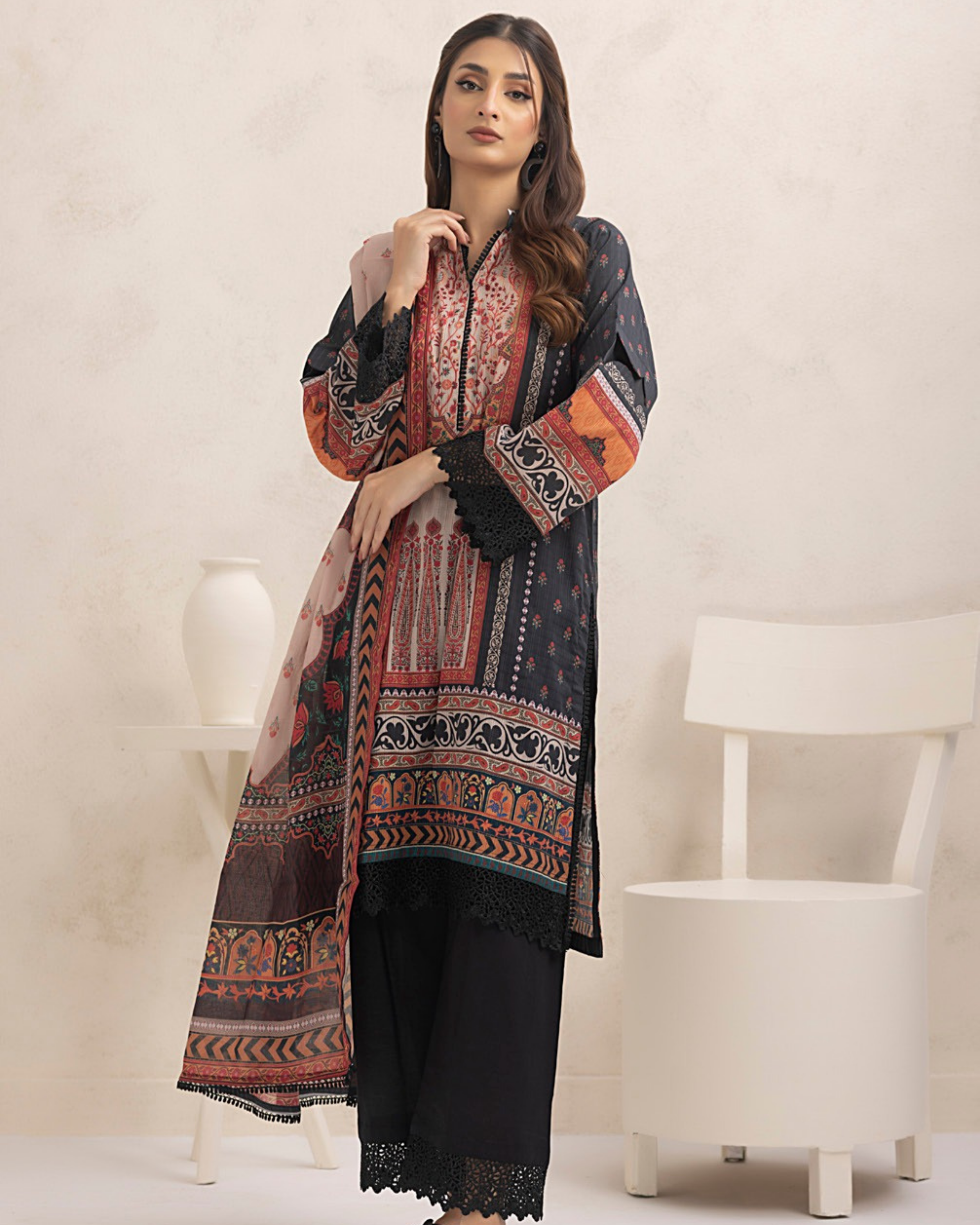 Woman wearing a long, patterned dress with a plain background