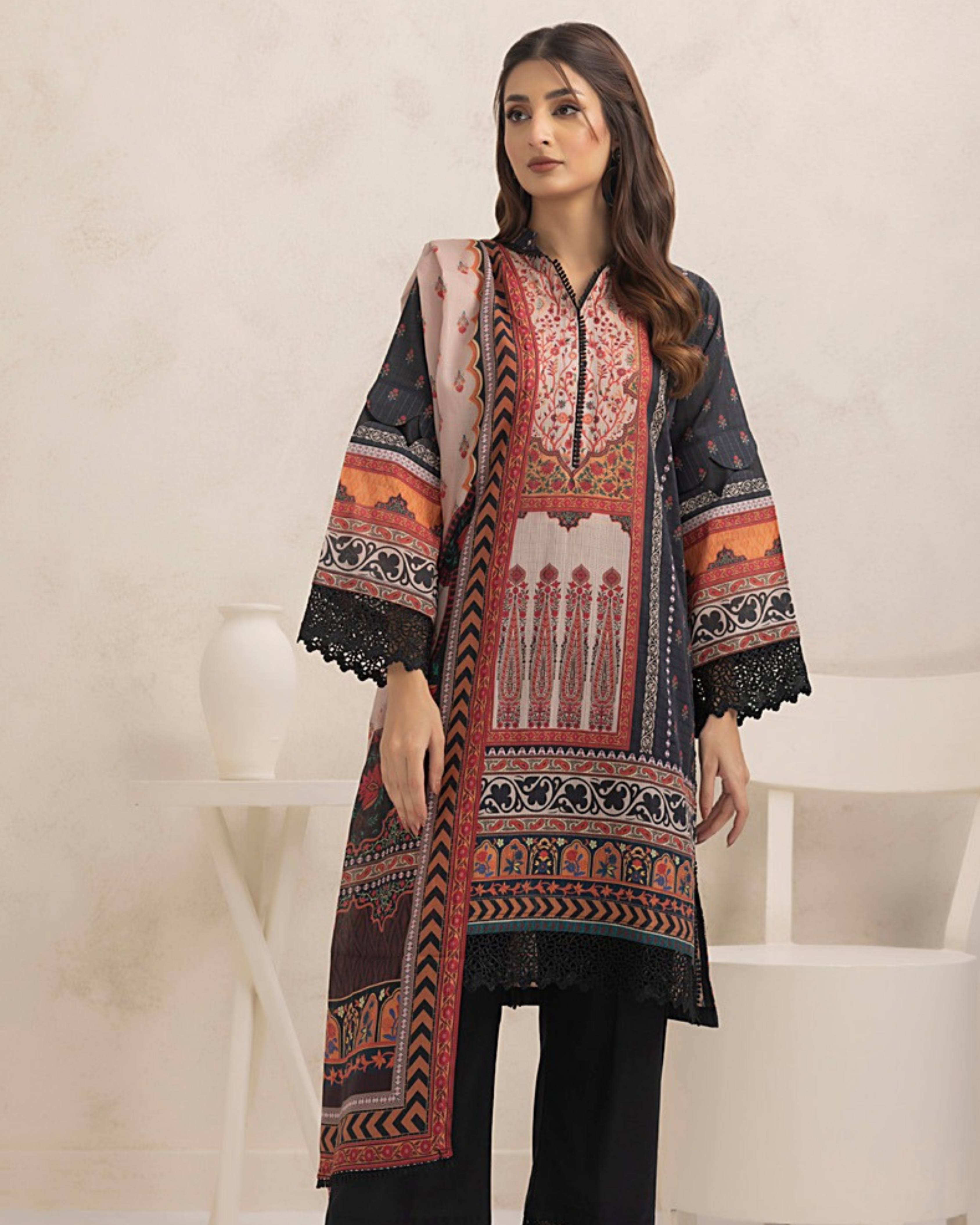 Woman wearing a patterned black and red kurta with a white background