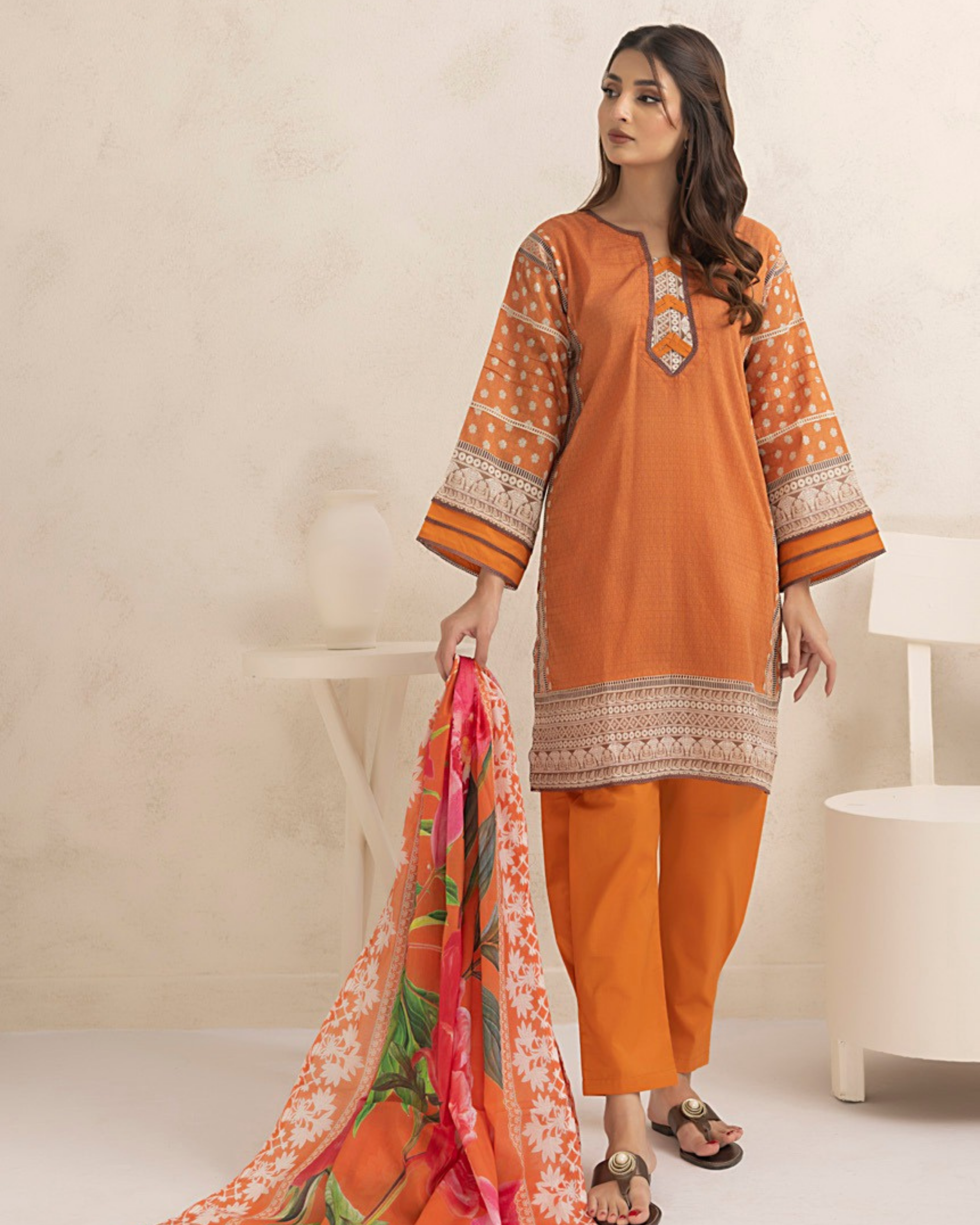 Woman wearing an orange traditional outfit with a white background
