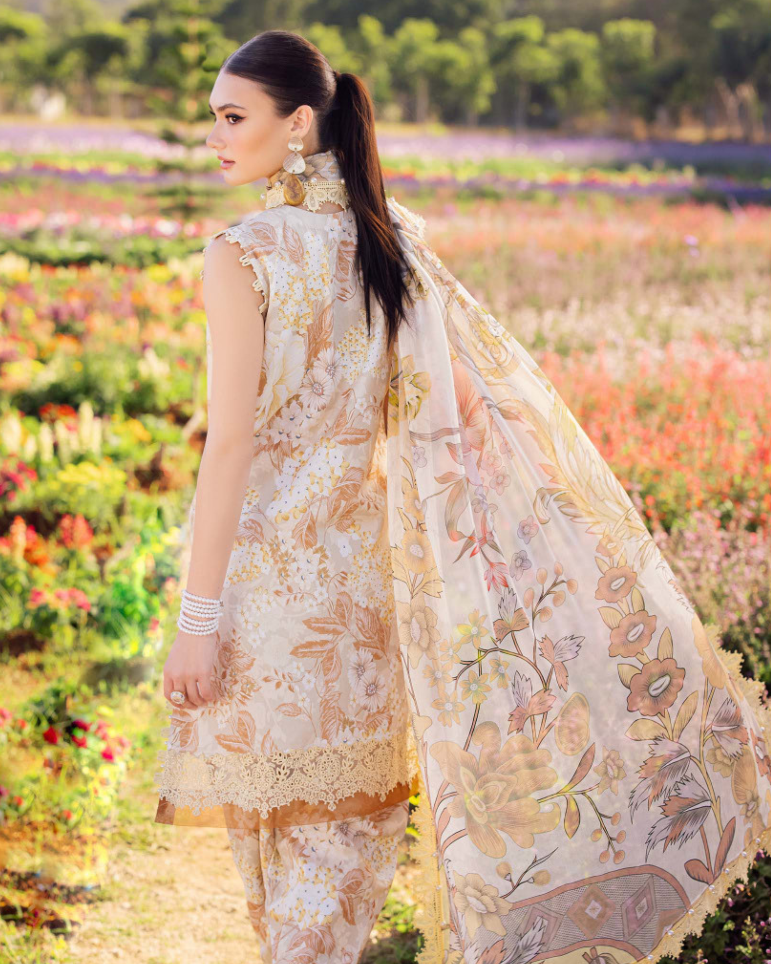Woman in a floral outfit standing in a field of flowers