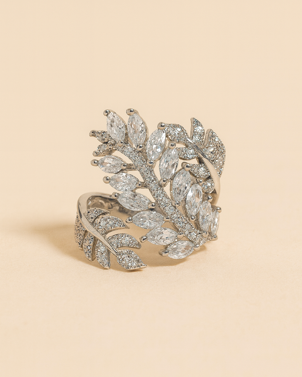 Silver leaf-shaped bracelet on a beige background