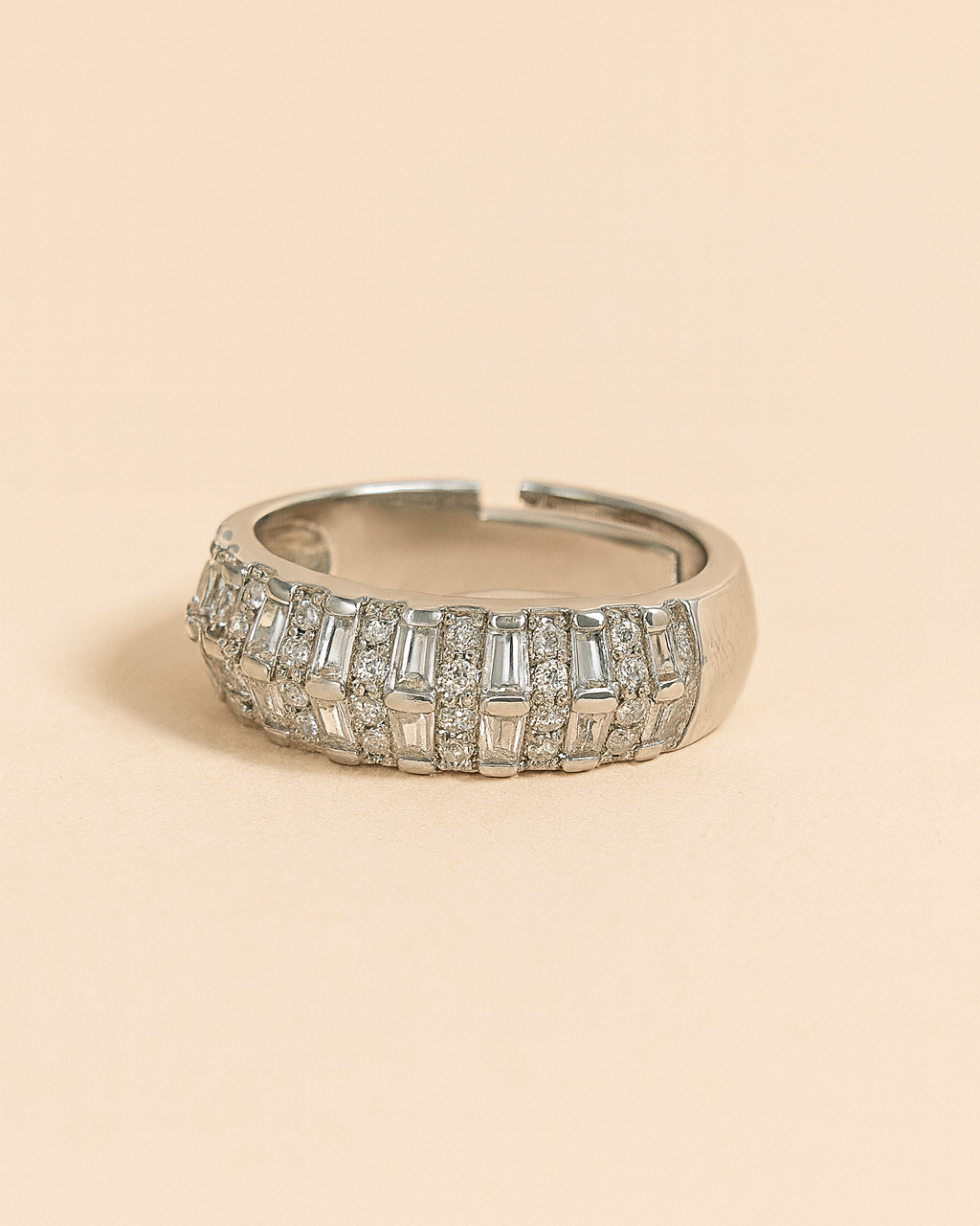 Silver ring with gemstones on a beige background