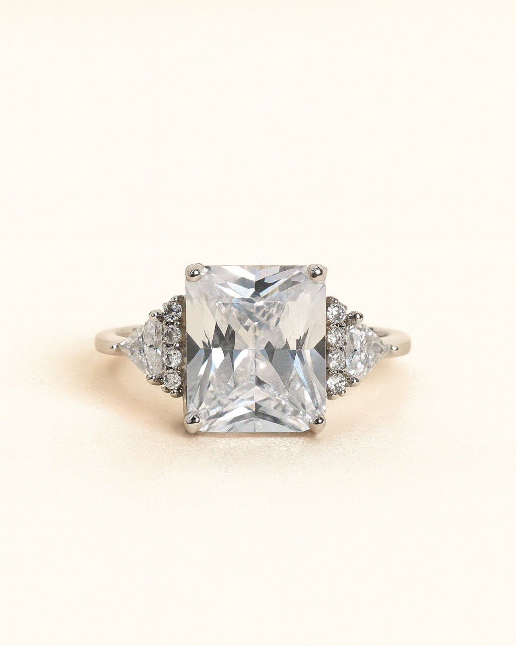 Diamond ring with a large central gemstone and smaller stones on a light background