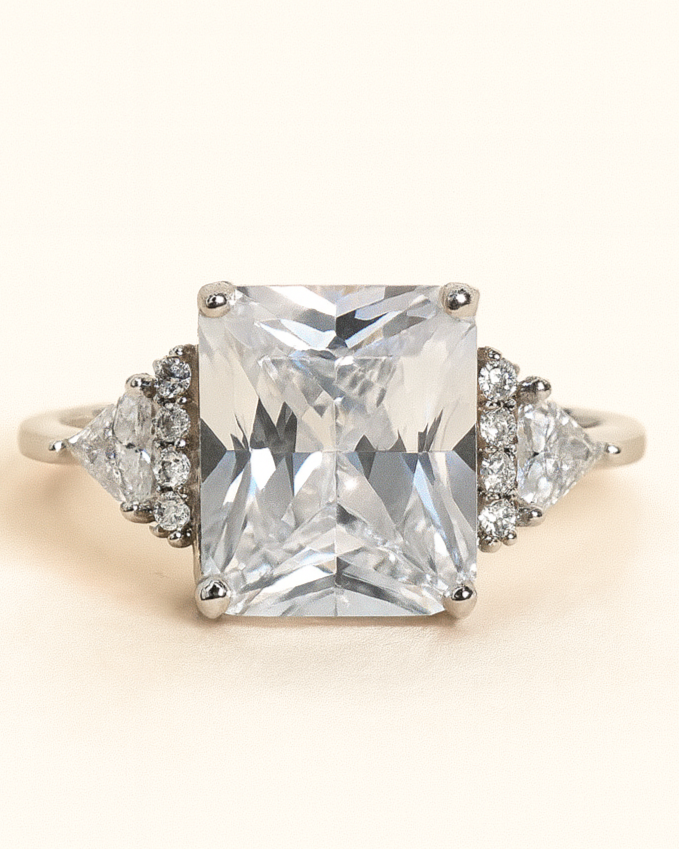 Diamond ring with a large central gemstone and smaller stones on a light background