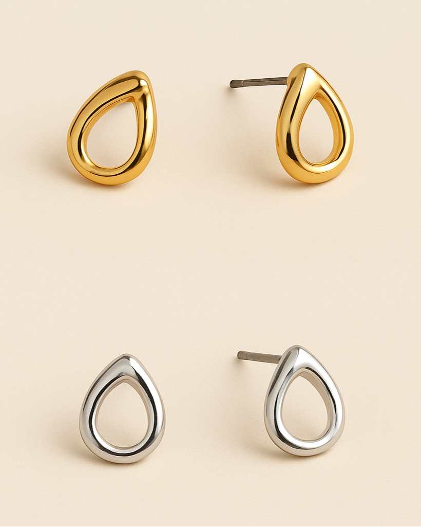 Gold and silver teardrop-shaped earrings on a beige background