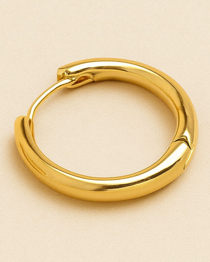 Gold hoop earrings on a beige background