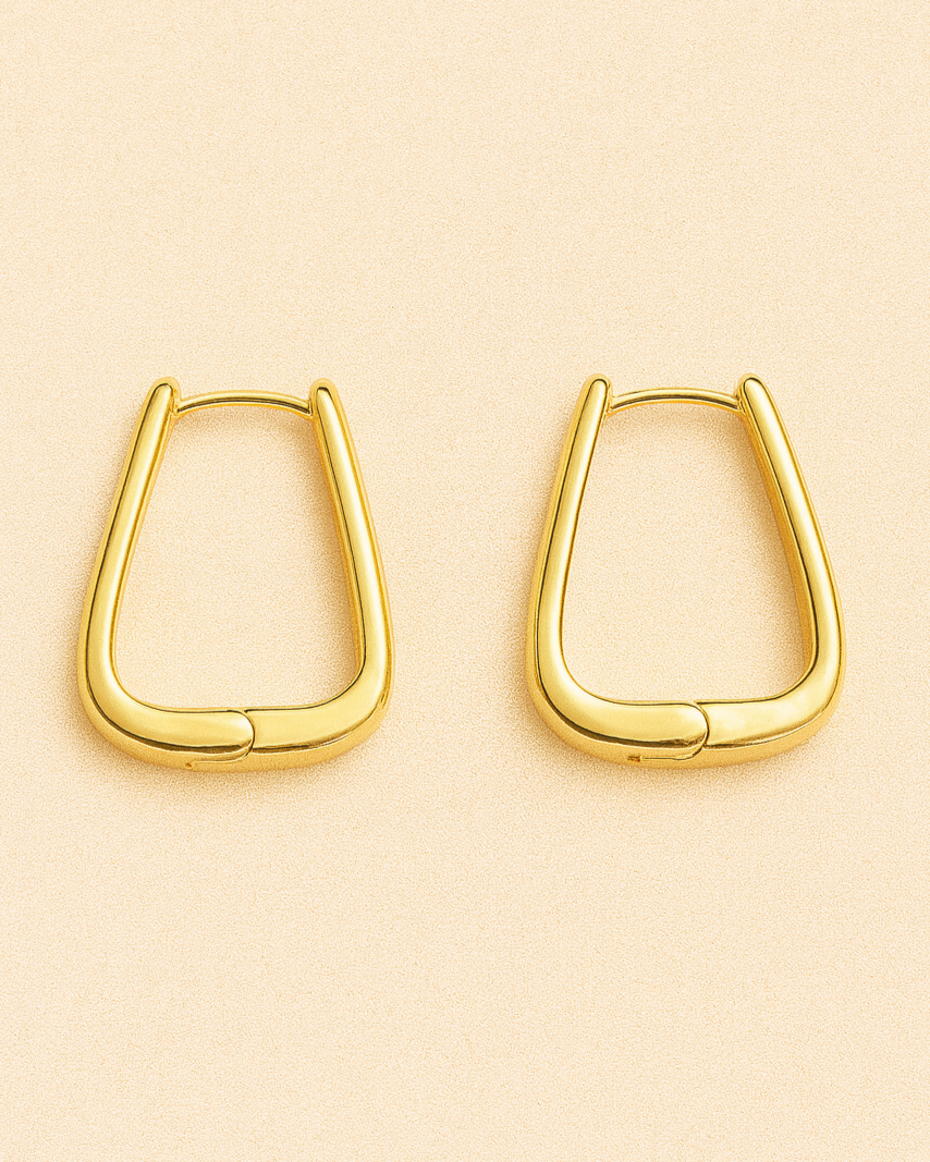 Gold hoop earrings on a beige background