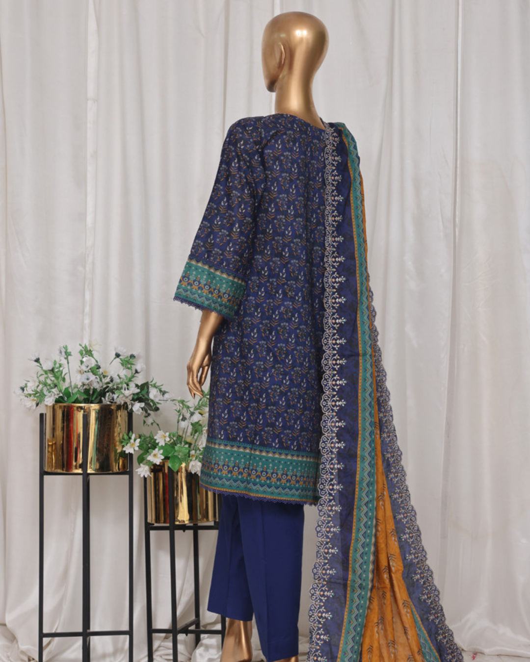 Mannequin wearing a navy blue embroidered outfit with a matching dupatta against a white curtain background.