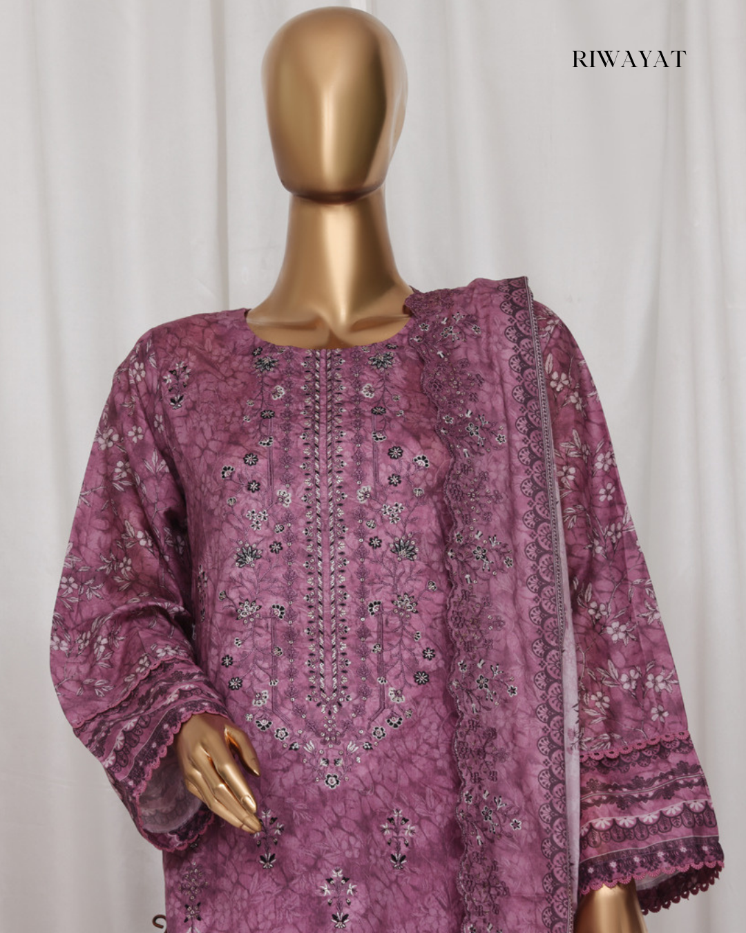 Mannequin wearing a purple embroidered outfit with 'RIWAYAT' branding.