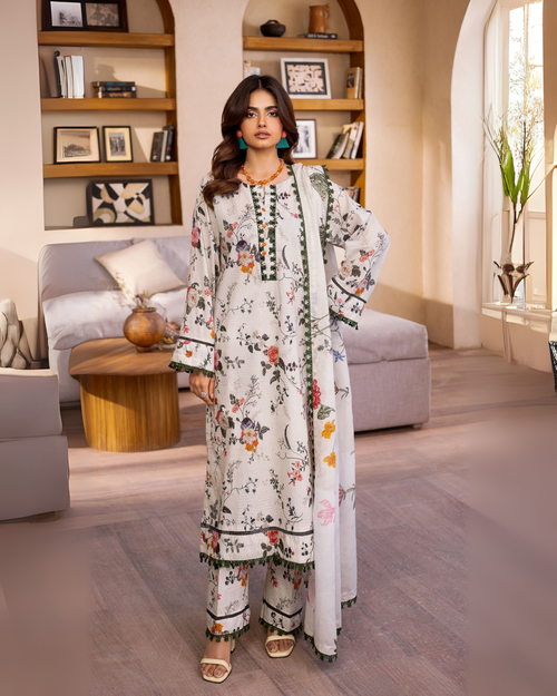 Woman in a floral outfit standing in a modern living room.
