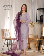 Woman in a lavender outfit with a purple dupatta standing in a room with decor elements.