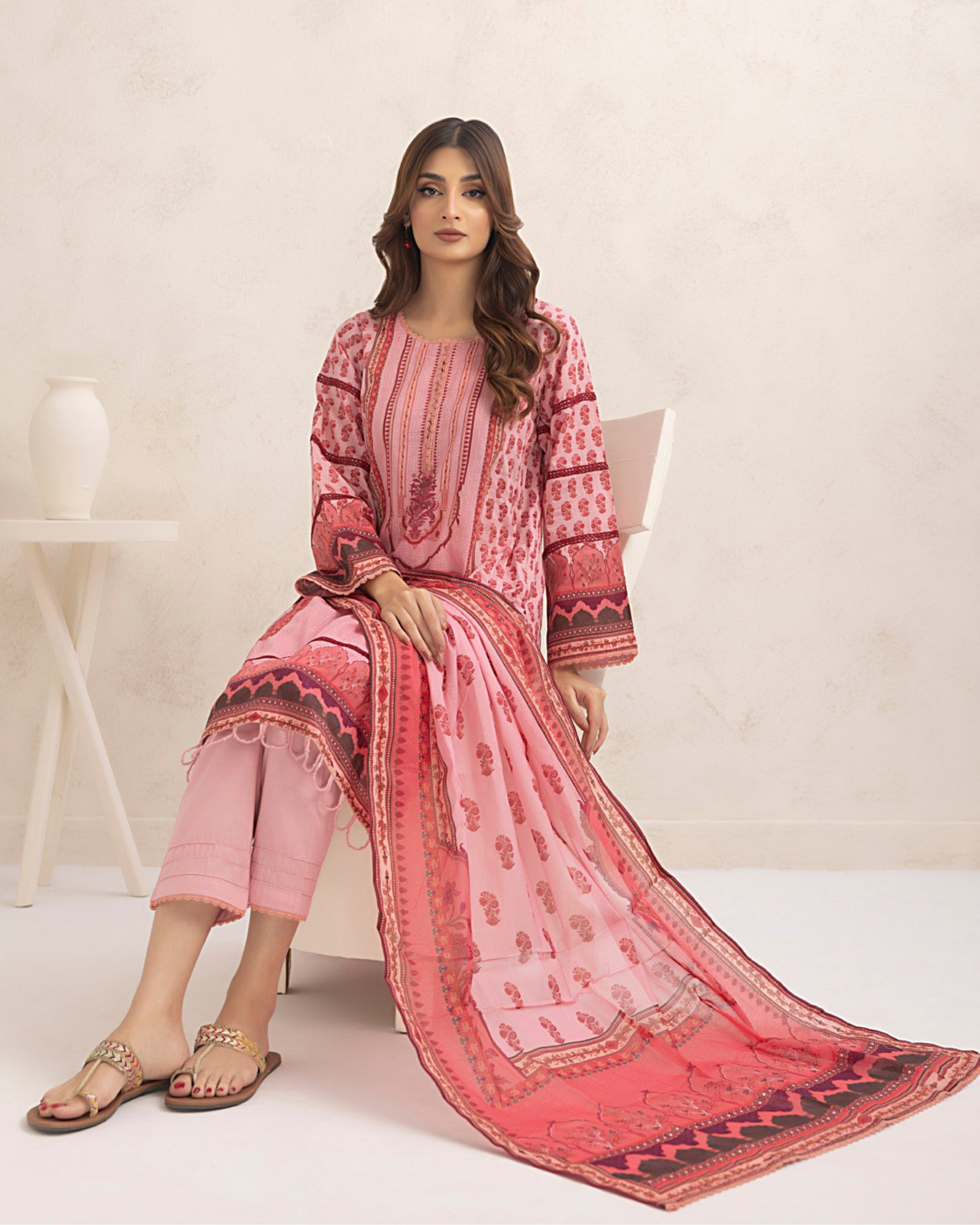 Woman wearing a pink traditional outfit with a matching dupatta on a white background