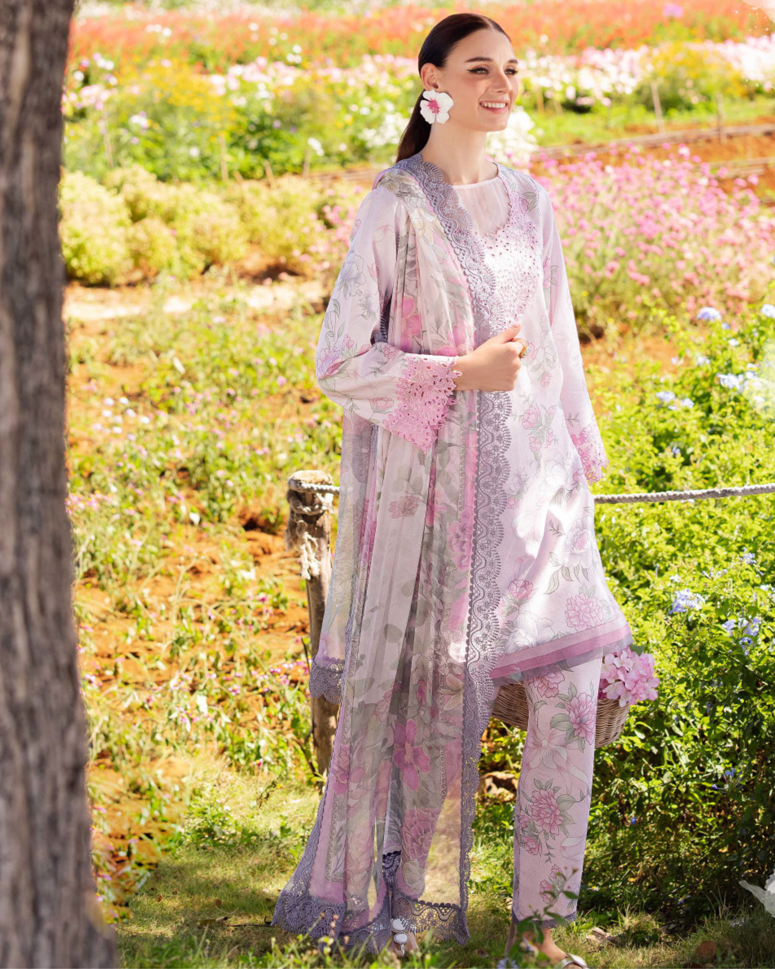 Woman in a floral outfit standing in a field of flowers