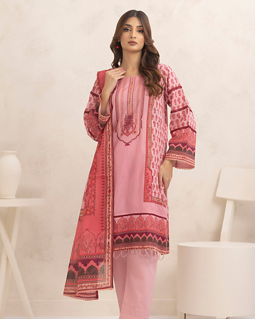 Woman wearing a pink and red patterned outfit in a minimalistic setting