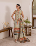 Woman wearing a floral dress with a matching dupatta in a room setting.