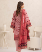 Woman wearing a red and pink patterned kurta with a white chair and table in the background