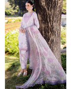Woman in a floral outfit standing next to a tree in a garden setting
