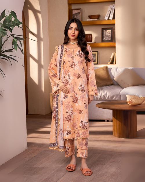 Woman in a floral dress standing in a well-lit room with a couch and table in the background.