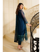 Woman in a navy blue traditional outfit with green lace standing on a staircase.