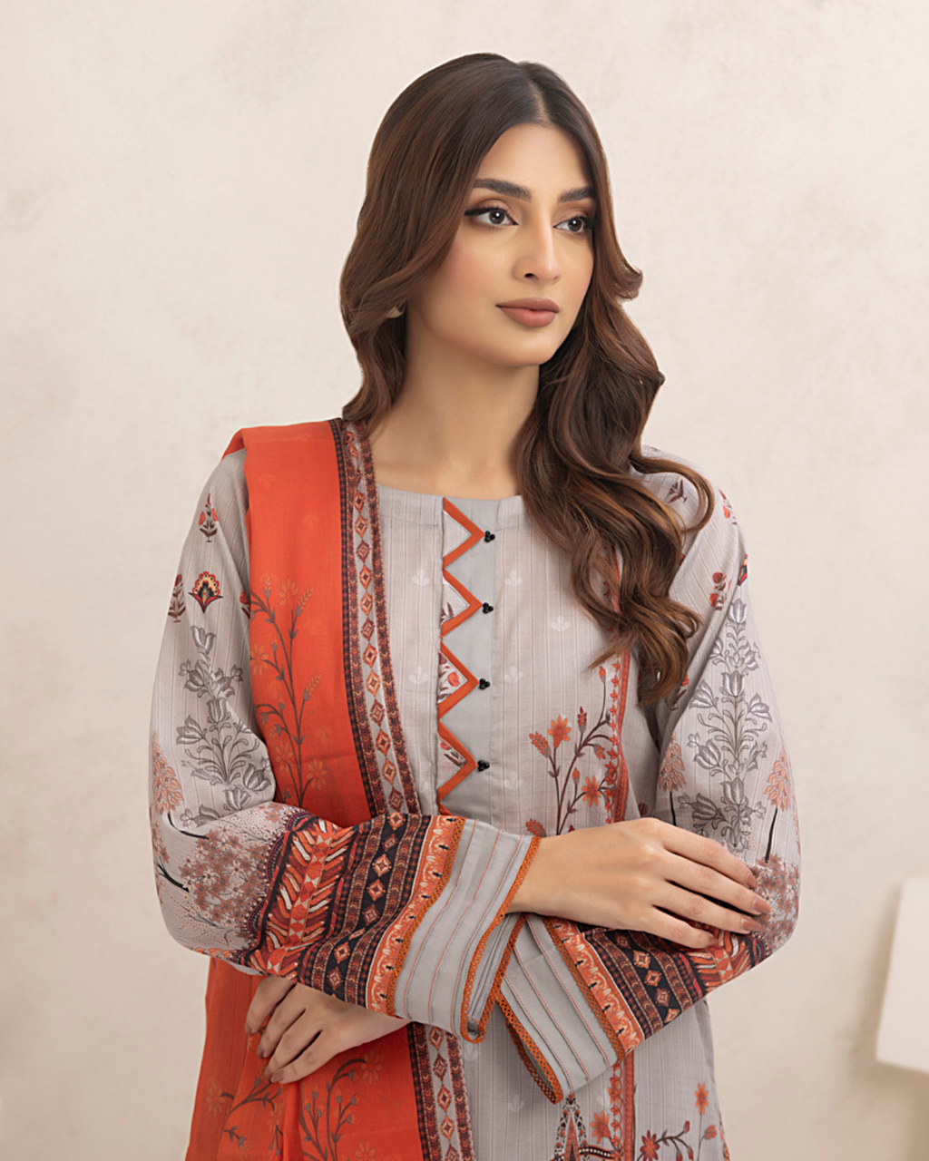 Woman wearing a traditional outfit with a red and white patterned jacket against a beige background