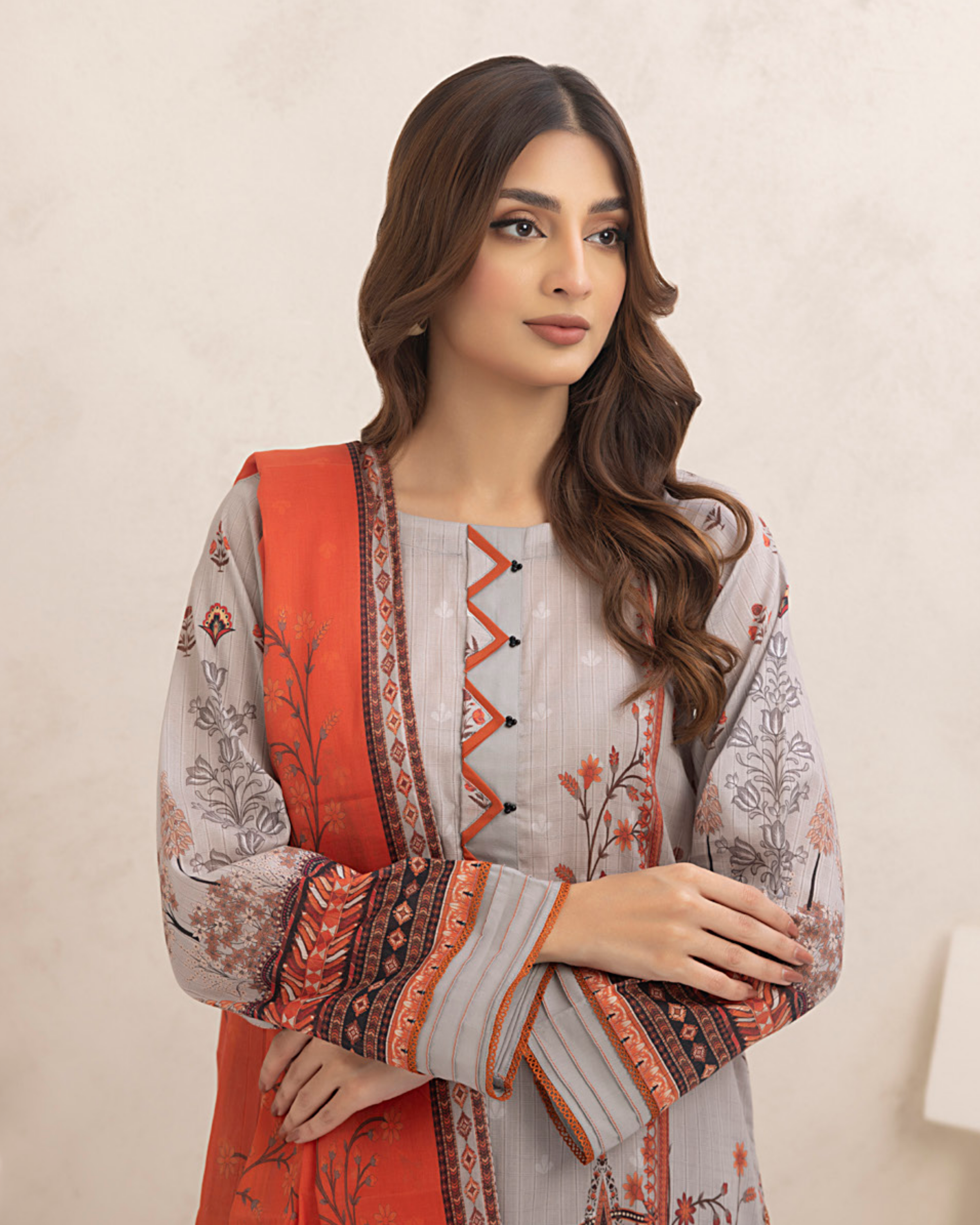 Woman wearing a traditional outfit with a red and white patterned jacket against a beige background