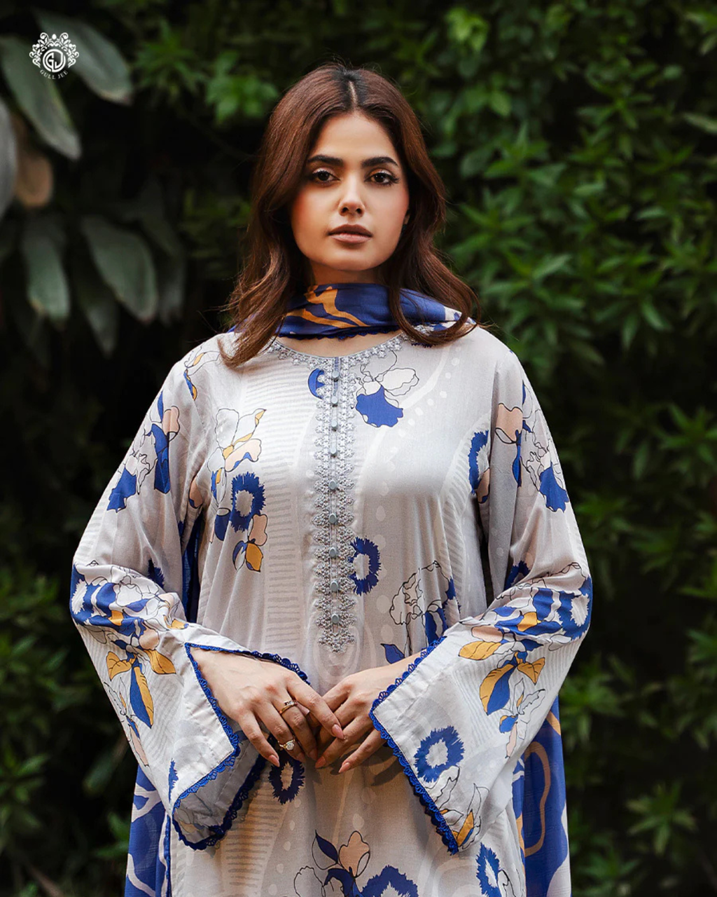 Woman wearing a floral-patterned outfit with a green leafy background