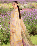 Woman in a yellow traditional outfit standing in a field of flowers