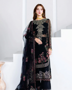 Woman wearing a black embroidered traditional outfit with a sheer overlay on a white background