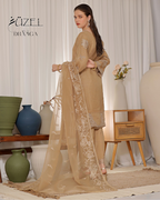 Woman in a beige traditional outfit with a sheer dupatta in a decorated room.