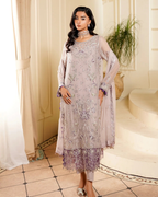 Woman wearing a light purple embroidered dress with a matching dupatta in an elegant indoor setting.