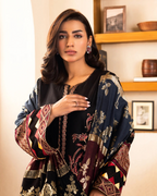 Woman wearing a black and patterned shawl indoors