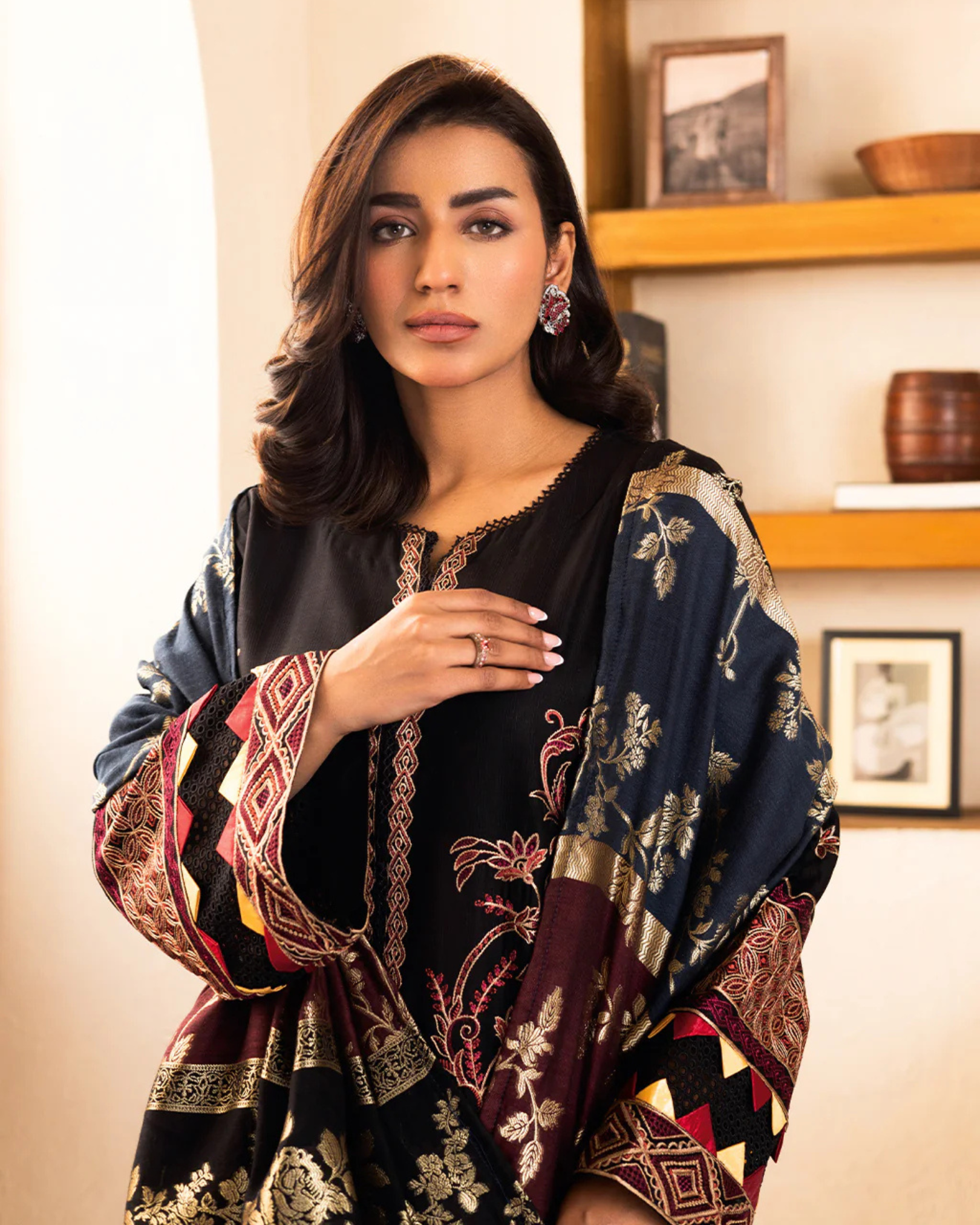 Woman wearing a black and patterned shawl indoors