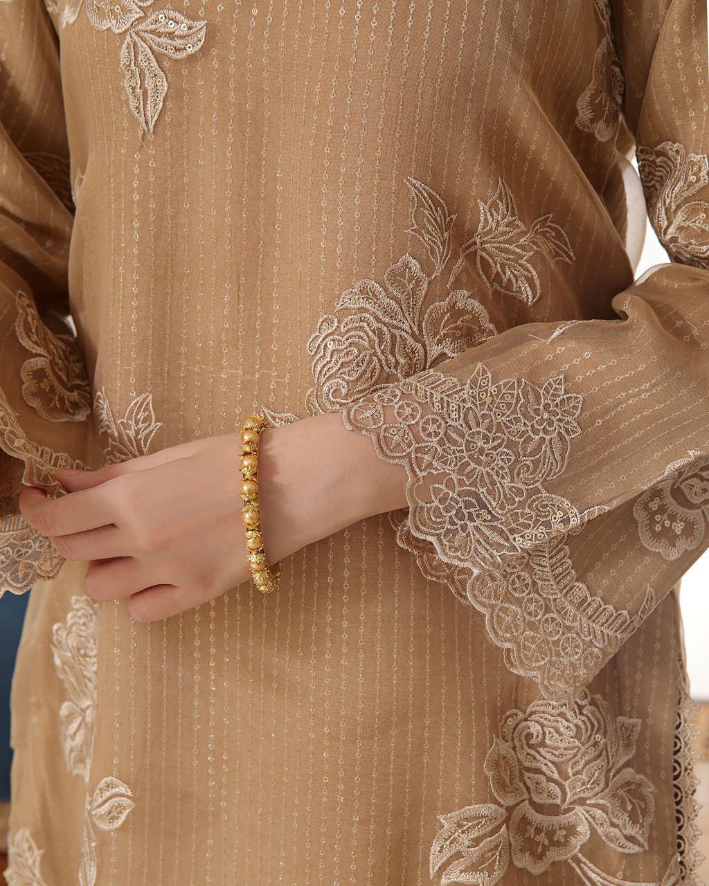 Close-up of a beige embroidered garment with floral patterns.