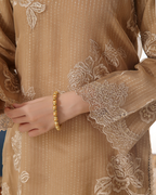 Close-up of a beige embroidered garment with floral patterns.