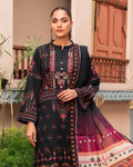 Woman wearing a black embroidered outfit with a colorful dupatta, standing outdoors.