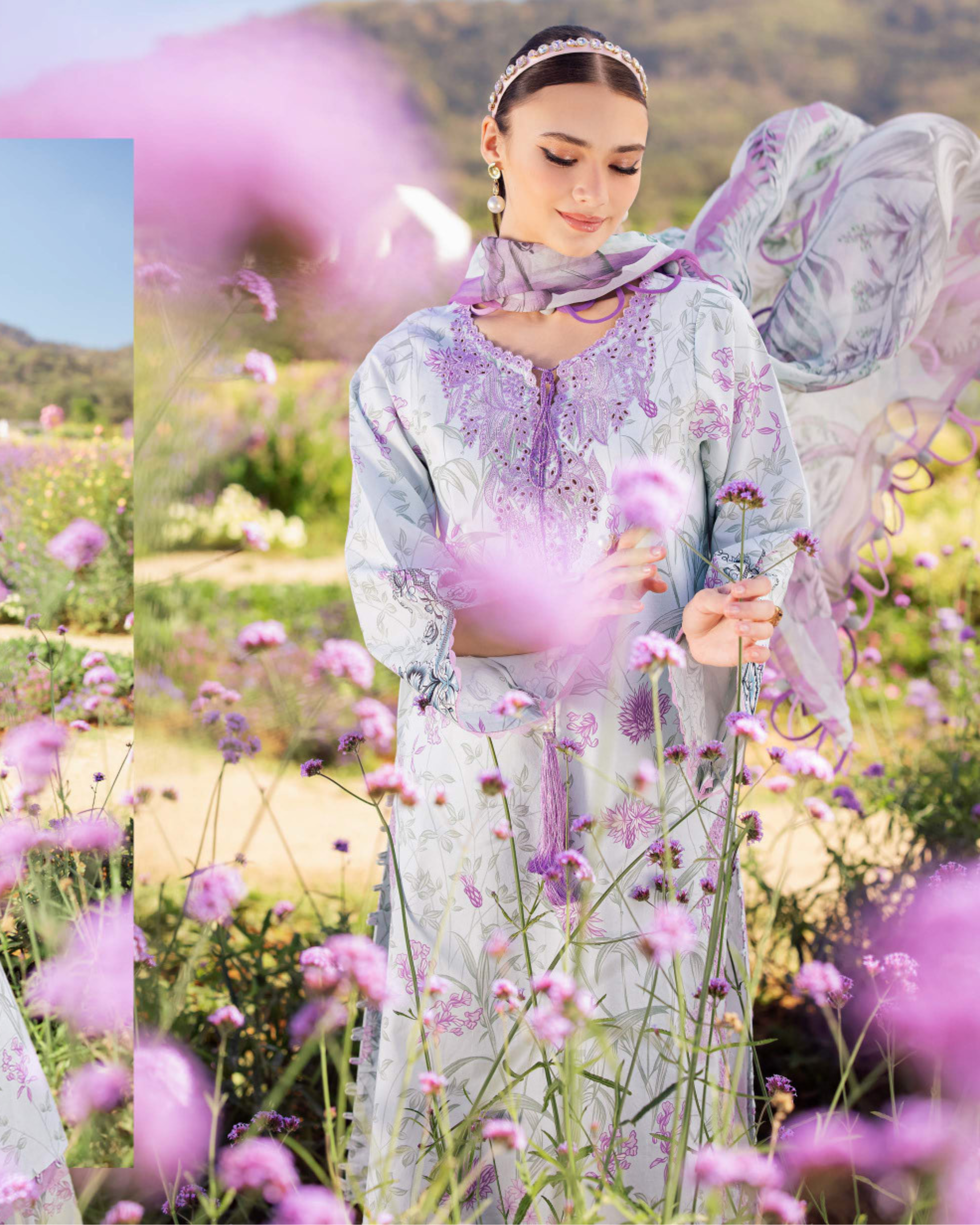 Woman in a light blue embroidered dress standing in a field of pink flowers