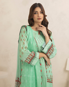Woman wearing a light green traditional outfit with floral patterns on a beige background